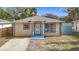 Charming single-story home featuring a blue and yellow color scheme and a well-manicured front lawn at 4503 Courtland St, Tampa, FL 33610