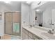Bright bathroom featuring a double sink vanity and glass-enclosed shower at 4557 Glen Holw, New Port Richey, FL 34653
