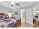 Comfortable bedroom featuring wood-look flooring, a ceiling fan, and access to an adjoining bathroom and kitchen at 4557 Glen Holw, New Port Richey, FL 34653