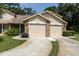 Well-maintained home exterior with attached two-car garage and manicured lawn at 4557 Glen Holw, New Port Richey, FL 34653