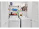 Neat laundry room with washer, dryer, storage shelves, and convenient bi-fold door at 4557 Glen Holw, New Port Richey, FL 34653