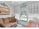 Cozy sunroom filled with light and featuring a sofa and white shutters at 4557 Glen Holw, New Port Richey, FL 34653