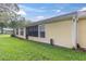 Expansive backyard with manicured lawn, complemented by the home's exterior with screened in patio at 4841 Wakefield Ct # 4841, New Port Richey, FL 34655