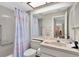 Bathroom boasts a shower-tub combo, a decorative shower curtain and a large mirror at 4841 Wakefield Ct # 4841, New Port Richey, FL 34655