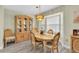 Formal dining room featuring a light wood table and chairs set illuminated by a unique chandelier and a display cabinet at 4841 Wakefield Ct # 4841, New Port Richey, FL 34655