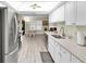 Open kitchen with stainless steel appliances, white cabinets, and a view into the breakfast nook and Gathering room at 4841 Wakefield Ct # 4841, New Port Richey, FL 34655