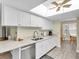 Bright kitchen with white cabinets, stainless steel appliances, a skylight, and a view into the breakfast area at 4841 Wakefield Ct # 4841, New Port Richey, FL 34655