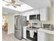 Bright kitchen features stainless steel appliances, white cabinetry, a skylight, and breakfast area at 4841 Wakefield Ct # 4841, New Port Richey, FL 34655