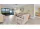 Bright living room with sliding glass doors leading to the lanai, wood-look floors, and comfortable seating at 4841 Wakefield Ct # 4841, New Port Richey, FL 34655