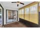 Cozy sunroom with natural light, ceiling fan, chair, and sliding glass door access to the yard at 4841 Wakefield Ct # 4841, New Port Richey, FL 34655