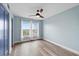 Empty bedroom features blue walls, light wood floors, and a ceiling fan at 4939 Floramar Ter # 611, New Port Richey, FL 34652