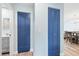 Hallway with two blue-toned doors leading to the bathroom and the open-concept dining/living areas at 4939 Floramar Ter # 611, New Port Richey, FL 34652