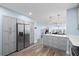 Open kitchen with stainless appliances, island and gray cabinets flowing into the living area at 4939 Floramar Ter # 611, New Port Richey, FL 34652