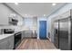 Renovated kitchen with stainless steel appliances, light wood floors, and blue door at 4939 Floramar Ter # 611, New Port Richey, FL 34652