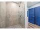 A glass enclosed shower features stone look tile and a built-in shelf and shower head at 4939 Floramar Ter # 611, New Port Richey, FL 34652