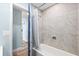 Modern tiled shower and bathtub with shower curtain; updated bathroom at 4939 Floramar Ter # 611, New Port Richey, FL 34652