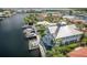 Aerial view of a luxurious two-story waterfront home featuring multiple boat docks and well manicured landscaping at 5145 Porpoise Pl, New Port Richey, FL 34652