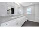 Bathroom featuring dual sinks, granite counters, modern fixtures, and ceramic tile flooring at 5145 Porpoise Pl, New Port Richey, FL 34652