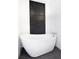 A stylish bathroom features a modern soaking tub and an accent wall with beautiful black mosaic tiles at 5145 Porpoise Pl, New Port Richey, FL 34652