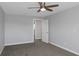 Bedroom with a ceiling fan, closet, doorway, neutral walls, and carpet flooring at 5145 Porpoise Pl, New Port Richey, FL 34652