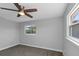 The serene bedroom features a ceiling fan, two windows for natural light, neutral paint, and soft gray carpeting at 5145 Porpoise Pl, New Port Richey, FL 34652