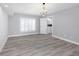 Spacious bedroom boasts hardwood flooring, neutral walls, and a modern chandelier at 5145 Porpoise Pl, New Port Richey, FL 34652