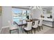 Dining room with modern chandelier, table, and view of pool at 5145 Porpoise Pl, New Port Richey, FL 34652