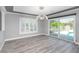Dining room featuring wood floors, a modern light fixture, a tray ceiling, and sliding glass doors to the pool at 5145 Porpoise Pl, New Port Richey, FL 34652