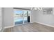 Bright dining room with an open floor plan, modern light fixture, and a sliding glass door to the pool at 5145 Porpoise Pl, New Port Richey, FL 34652