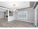 Dining room featuring an open floor plan, a modern light fixture, wood floors, and plantation shutters at 5145 Porpoise Pl, New Port Richey, FL 34652