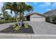 Charming home featuring a well-maintained lawn, beautiful flowers, and a paved driveway at 5145 Porpoise Pl, New Port Richey, FL 34652