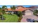 Beautiful single-story home with a paved driveway, lush green lawn, and tropical landscaping at 5145 Porpoise Pl, New Port Richey, FL 34652
