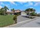Beautiful single-story home with a paved driveway, lush green lawn, and tropical landscaping at 5145 Porpoise Pl, New Port Richey, FL 34652