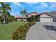 Lovely home with a lush lawn, mature trees, and a paved driveway leading to a two-car garage at 5145 Porpoise Pl, New Port Richey, FL 34652