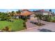 Charming single-Gathering home showcasing a lush green lawn, mature trees, and a brick paver driveway at 5145 Porpoise Pl, New Port Richey, FL 34652