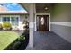 Inviting front entryway with a wood door, tile flooring and manicured landscaping at 5145 Porpoise Pl, New Port Richey, FL 34652