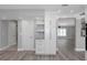 Hallway featuring a pantry, floating shelves, luxury vinyl plank flooring, and views into other rooms at 5145 Porpoise Pl, New Port Richey, FL 34652