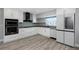 Modern kitchen with white cabinets, stainless steel appliances, granite countertops, and tile backsplash at 5145 Porpoise Pl, New Port Richey, FL 34652
