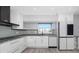 Modern kitchen features stainless steel appliances, stylish backsplash, and bright white cabinetry at 5145 Porpoise Pl, New Port Richey, FL 34652
