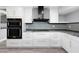 Modern kitchen with stainless steel double ovens, custom cabinetry, granite counters and stainless steel appliances at 5145 Porpoise Pl, New Port Richey, FL 34652