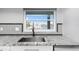 Close up of a modern kitchen sink and countertop with a view of the water and other homes at 5145 Porpoise Pl, New Port Richey, FL 34652