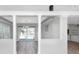 Bright living room with an open floor plan, modern light fixture, and access to an outdoor pool area at 5145 Porpoise Pl, New Port Richey, FL 34652