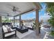 Covered patio with furniture, ceiling fans, and view of pool and waterfront at 5145 Porpoise Pl, New Port Richey, FL 34652