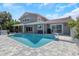 Gorgeous pool with a waterfall feature, waterfront views, and a tiled patio and back of house at 5145 Porpoise Pl, New Port Richey, FL 34652