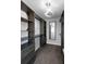 A walk-in closet featuring custom built-ins, and shelving with a modern light fixture at 5145 Porpoise Pl, New Port Richey, FL 34652