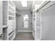 Organized walk-in closet with custom shelving and ample storage; the mirror faces the entry at 5145 Porpoise Pl, New Port Richey, FL 34652