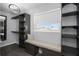 This walk-in closet boasts custom shelving, storage, a cushioned bench, and a bright window at 5145 Porpoise Pl, New Port Richey, FL 34652