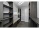 Custom walk-in closet boasts ample shelving, drawers, seating area, modern lighting and neutral gray carpeting at 5145 Porpoise Pl, New Port Richey, FL 34652