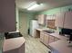 Functional kitchen with pink countertops, light pink cabinets, and standard appliances at 5391 Pillar Ave, Spring Hill, FL 34608