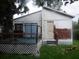Exterior view of a one-story home featuring a small deck and partial paint job at 5625 Van Doren Ave, New Port Richey, FL 34652